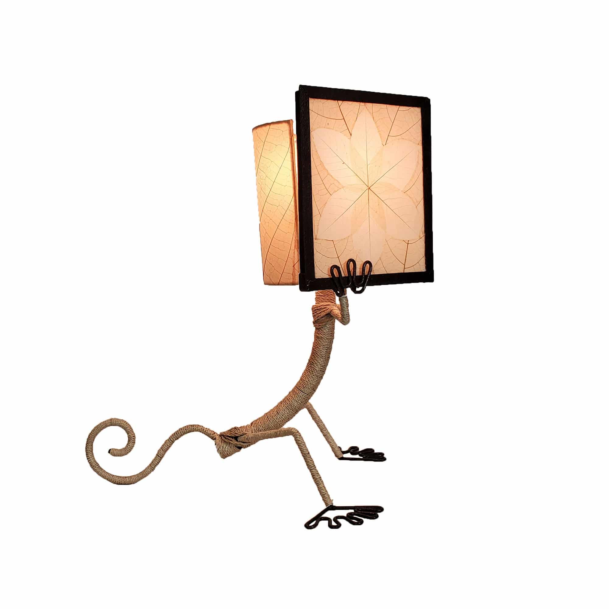 Crafted by the artisans of Eangee Home Design, the Enlightened Gecko Table Lamp in natural against a clean backdrop, featuring fossilized cocoa leaf shade, guyabano leaf shade, abaca rope accents, wrought iron frame, handcrafted.