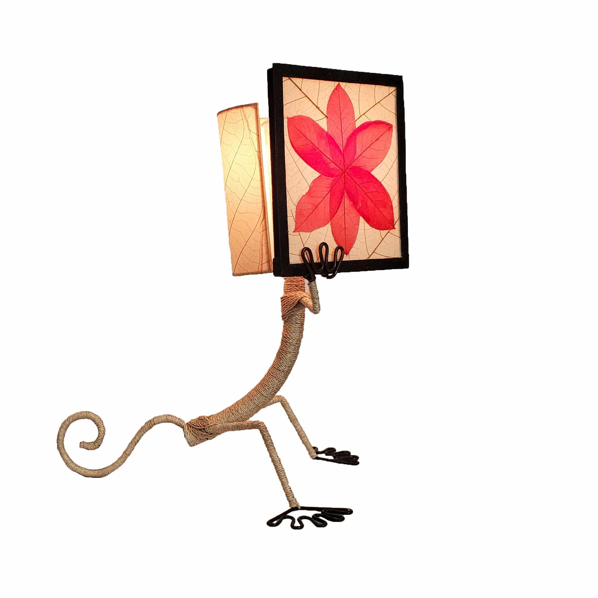 Crafted by the artisans of Eangee Home Design, the Enlightened Gecko Table Lamp in red against a clean backdrop, featuring fossilized cocoa leaf shade, guyabano leaf shade, abaca rope accents, wrought iron frame, handcrafted.