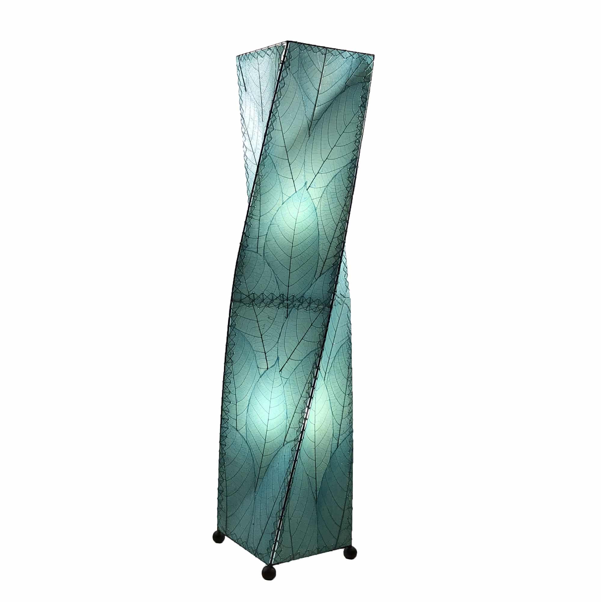 In a sun drenched entryway, crafted by the artisans of Eangee Home Design, the Twist Large Floor Lamp in sea blue stands gracefully, featuring fossilized cocoa leaf shade, wrought iron frame, sustainably sourced, handcrafted, adding warmth and character to the space.