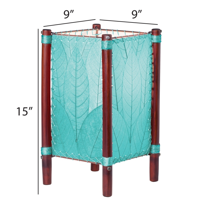 Crafted by the artisans of Eangee Home Design, the Fortune Table Lamp in sea blue against a clean backdrop, featuring fossilized cocoa leaf shade, abaca rope accents, rattan leg supports.