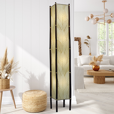In a minimalist loft with natural textures, crafted by the artisans of Eangee Home Design, the Fortune Giant Floor Lamp in natural stands gracefully, featuring fossilized cocoa leaf shade, abaca rope accents, rattan leg supports, wrought iron frame, eco friendly, adding warmth and character to the space.