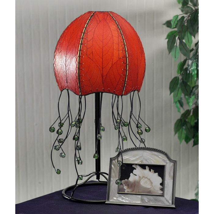 In a modern interior with earth tones, crafted by the artisans of Eangee Home Design, the Jellyfish Table Lamp in red stands gracefully, featuring fossilized cocoa leaf shade, abaca rope accents, wrought iron frame, handcrafted, adding warmth and character to the space.