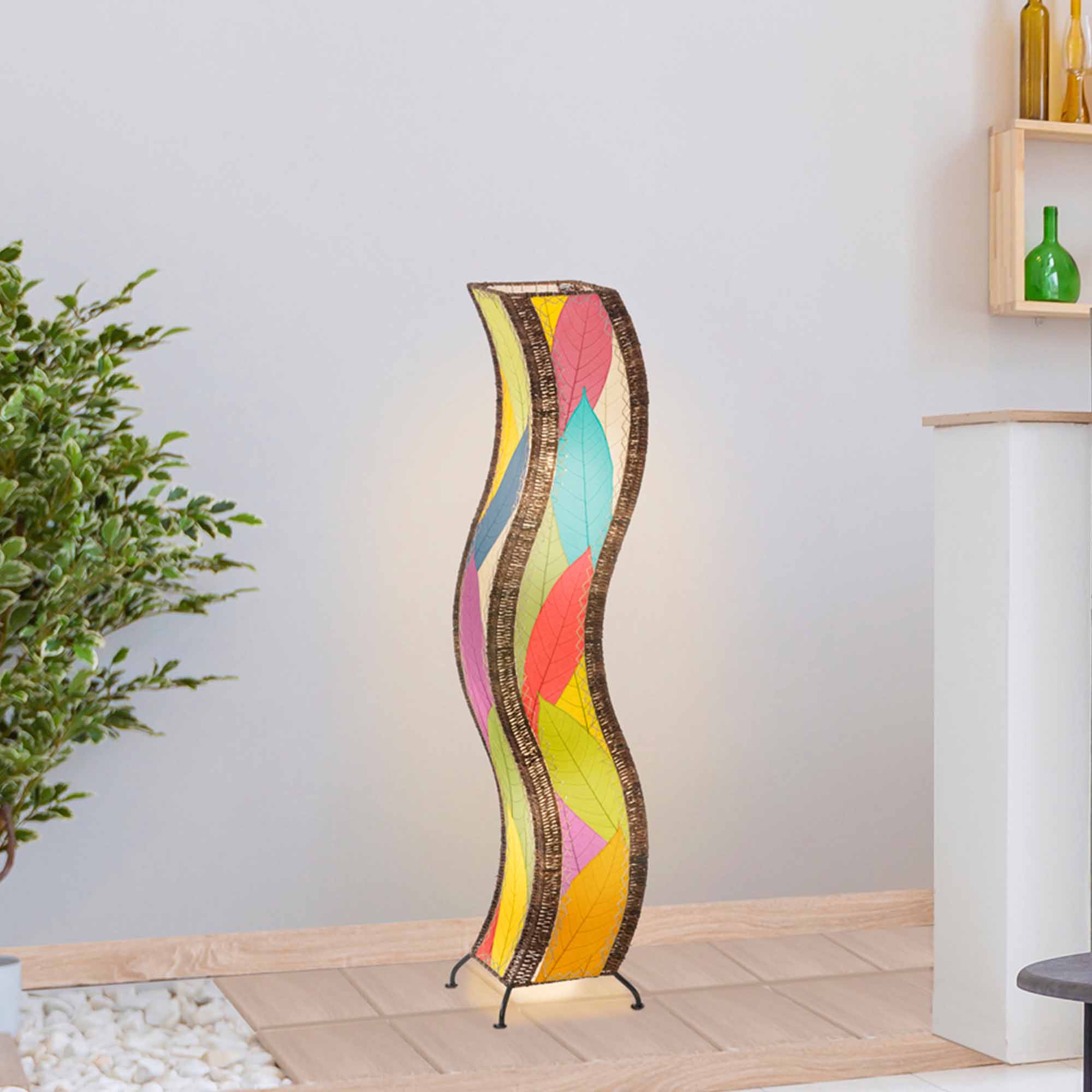 In a coastal inspired living room, crafted by the artisans of Eangee Home Design, the Wave Large Floor Lamp in multi color stands gracefully, featuring fossilized cocoa leaf shade, abaca rope accents, handcrafted, adding warmth and character to the space.