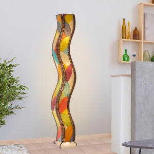 In a coastal inspired living room, crafted by the artisans of Eangee Home Design, the Wave Giant Floor Lamp in multi color stands gracefully, featuring fossilized cocoa leaf shade, abaca rope accents, eco friendly, handcrafted, adding warmth and character to the space.