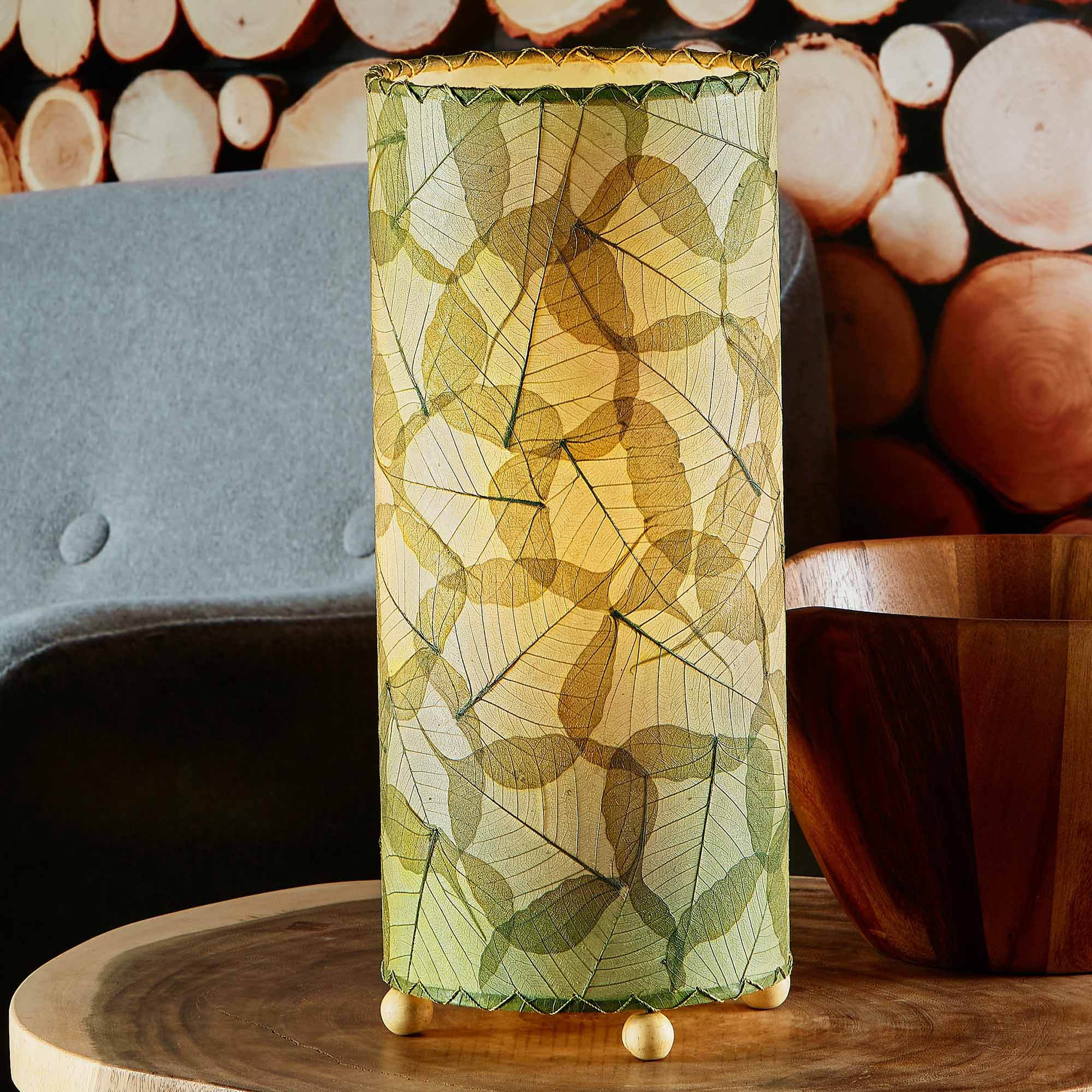 In a coastal inspired living room, crafted by the artisans of Eangee Home Design, the Banyan Table Lamp in green stands gracefully, featuring wrought iron frame, eco friendly, adding warmth and character to the space.