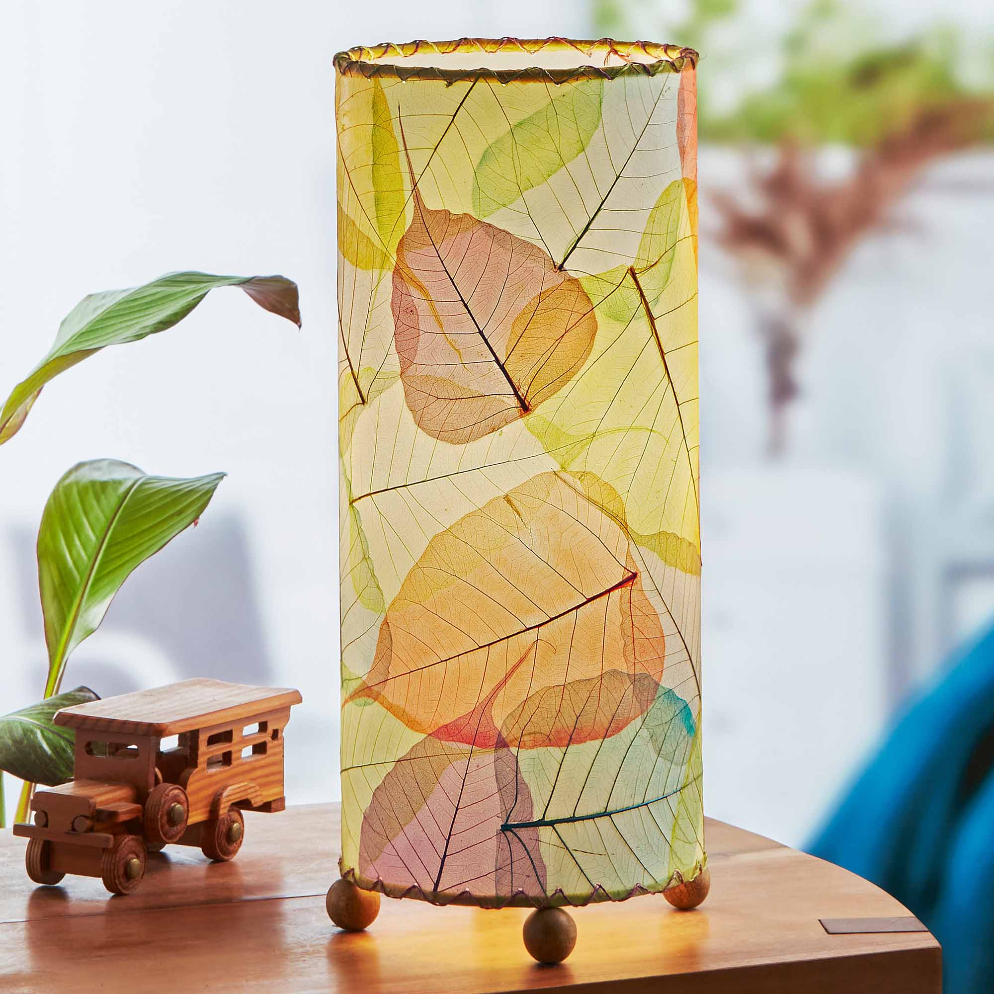 In a modern interior with earth tones, crafted by the artisans of Eangee Home Design, the Banyan Table Lamp in multi color stands gracefully, featuring wrought iron frame, eco friendly, adding warmth and character to the space.