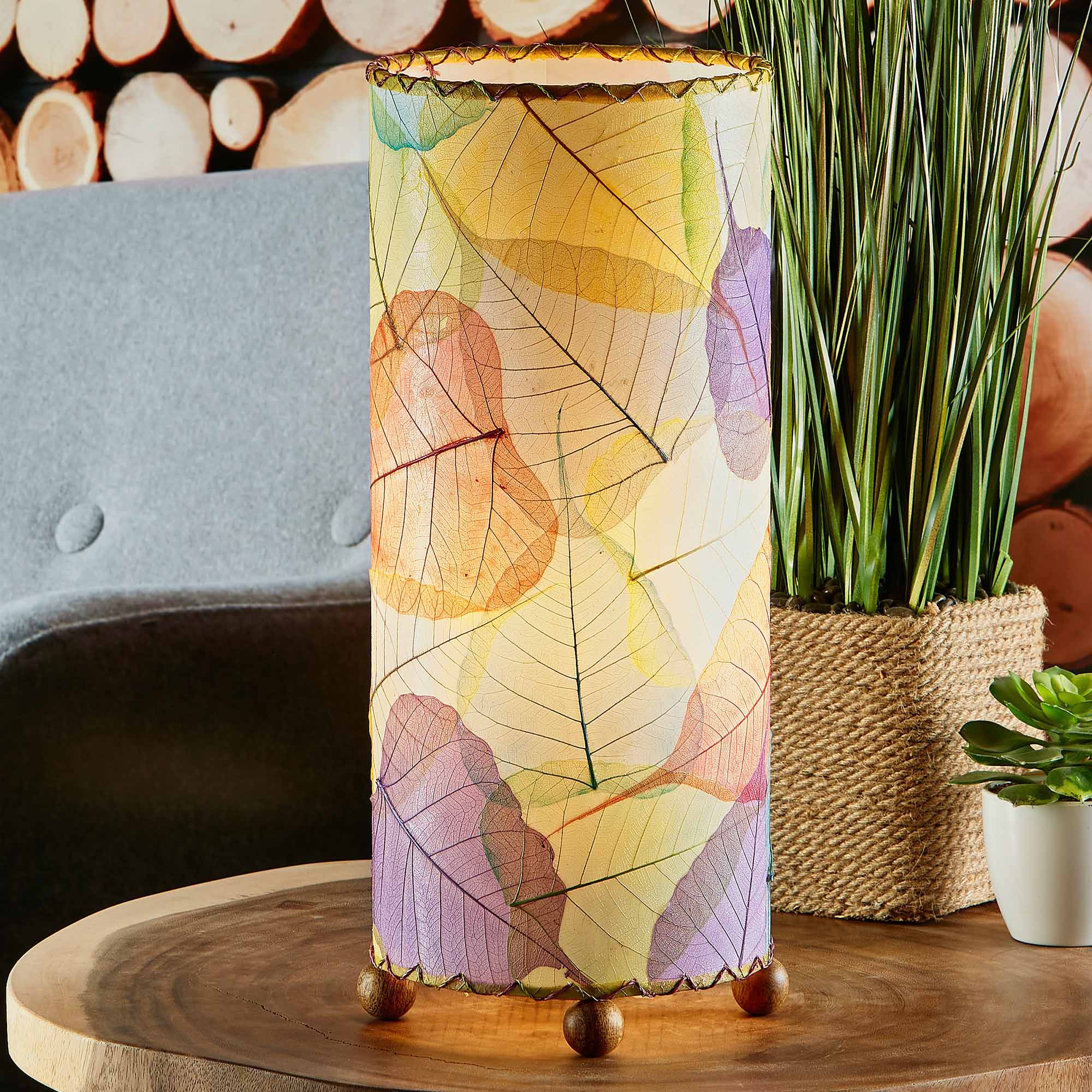 In a coastal inspired living room, crafted by the artisans of Eangee Home Design, the Banyan Table Lamp in multi color stands gracefully, featuring wrought iron frame, eco friendly, adding warmth and character to the space.