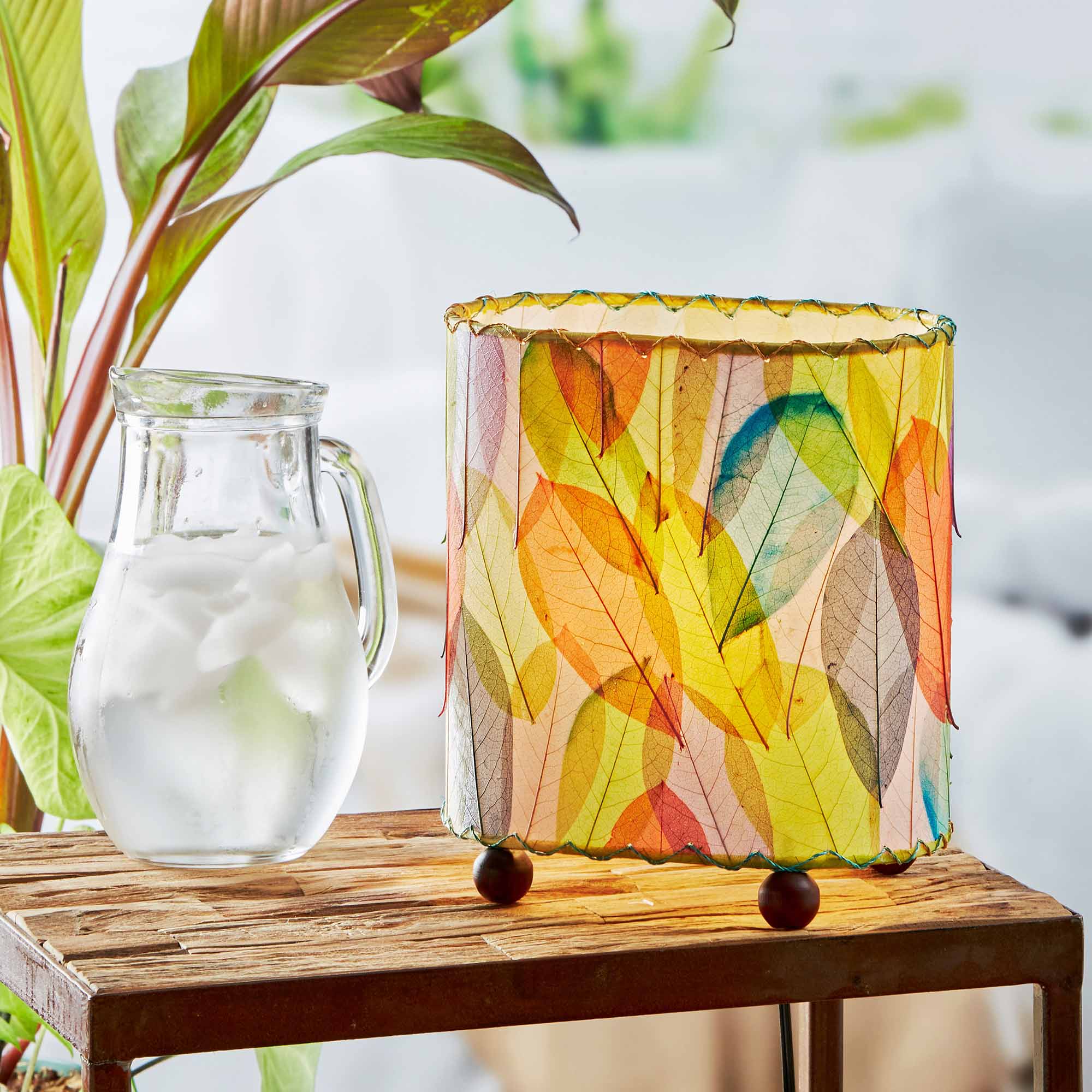 In a coastal inspired living room, crafted by the artisans of Eangee Home Design, the Mini Guyabano Table Lamp in multi color stands gracefully, featuring fossilized cocoa leaf shade, guyabano leaf shade, wrought iron frame, adding warmth and character to the space.