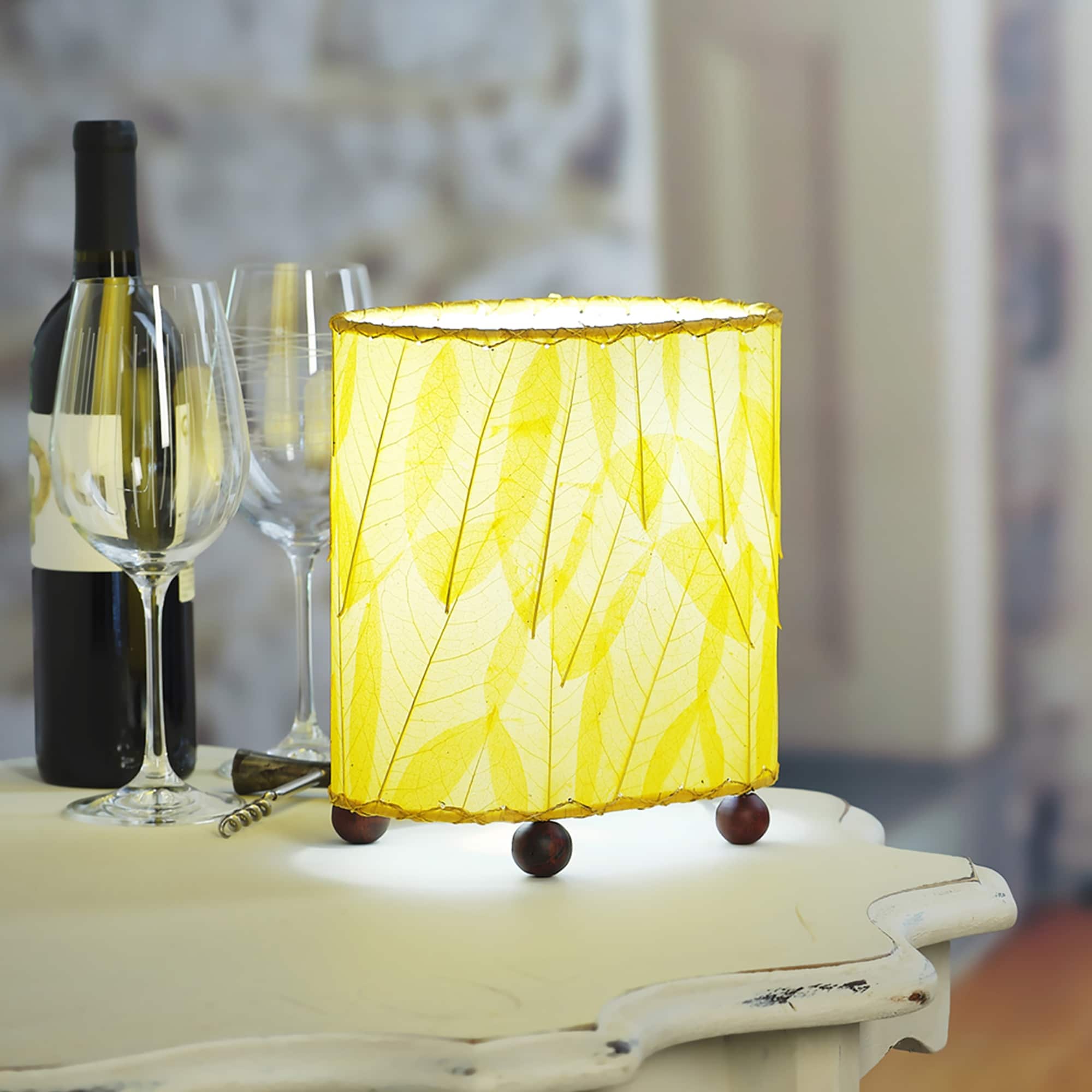 Crafted by the artisans of Eangee Home Design, the Mini Guyabano Table Lamp in yellow against a clean backdrop, featuring fossilized cocoa leaf shade, guyabano leaf shade, wrought iron frame.