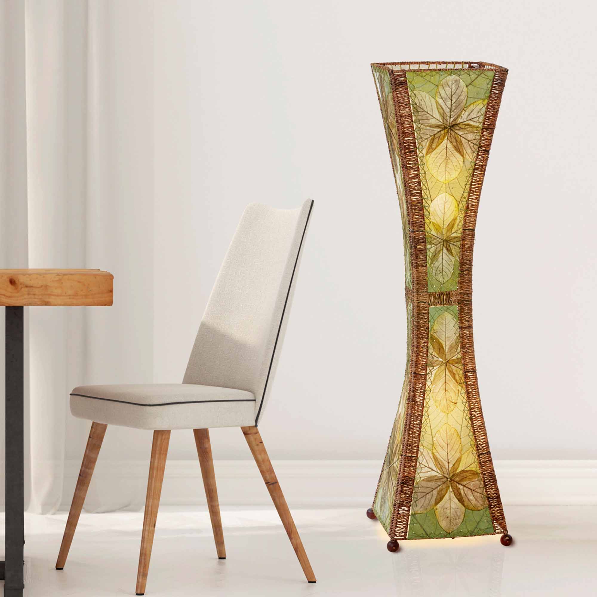 In a minimalist loft with natural textures, crafted by the artisans of Eangee Home Design, the Hourglass Large Floor Lamp in green stands gracefully, featuring jackfruit leaf panels, abaca rope accents, fair trade, eco friendly, sustainably sourced, adding warmth and character to the space.