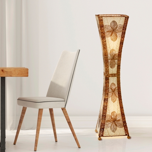 In a sun drenched entryway, crafted by the artisans of Eangee Home Design, the Hourglass Large Floor Lamp in natural stands gracefully, featuring jackfruit leaf panels, abaca rope accents, fair trade, eco friendly, sustainably sourced, adding warmth and character to the space.
