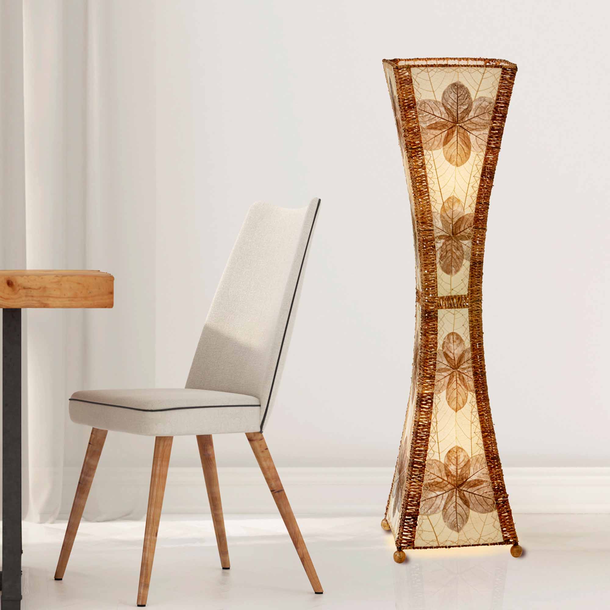 In a sun drenched entryway, crafted by the artisans of Eangee Home Design, the Hourglass Large Floor Lamp in natural stands gracefully, featuring jackfruit leaf panels, abaca rope accents, fair trade, eco friendly, sustainably sourced, adding warmth and character to the space.