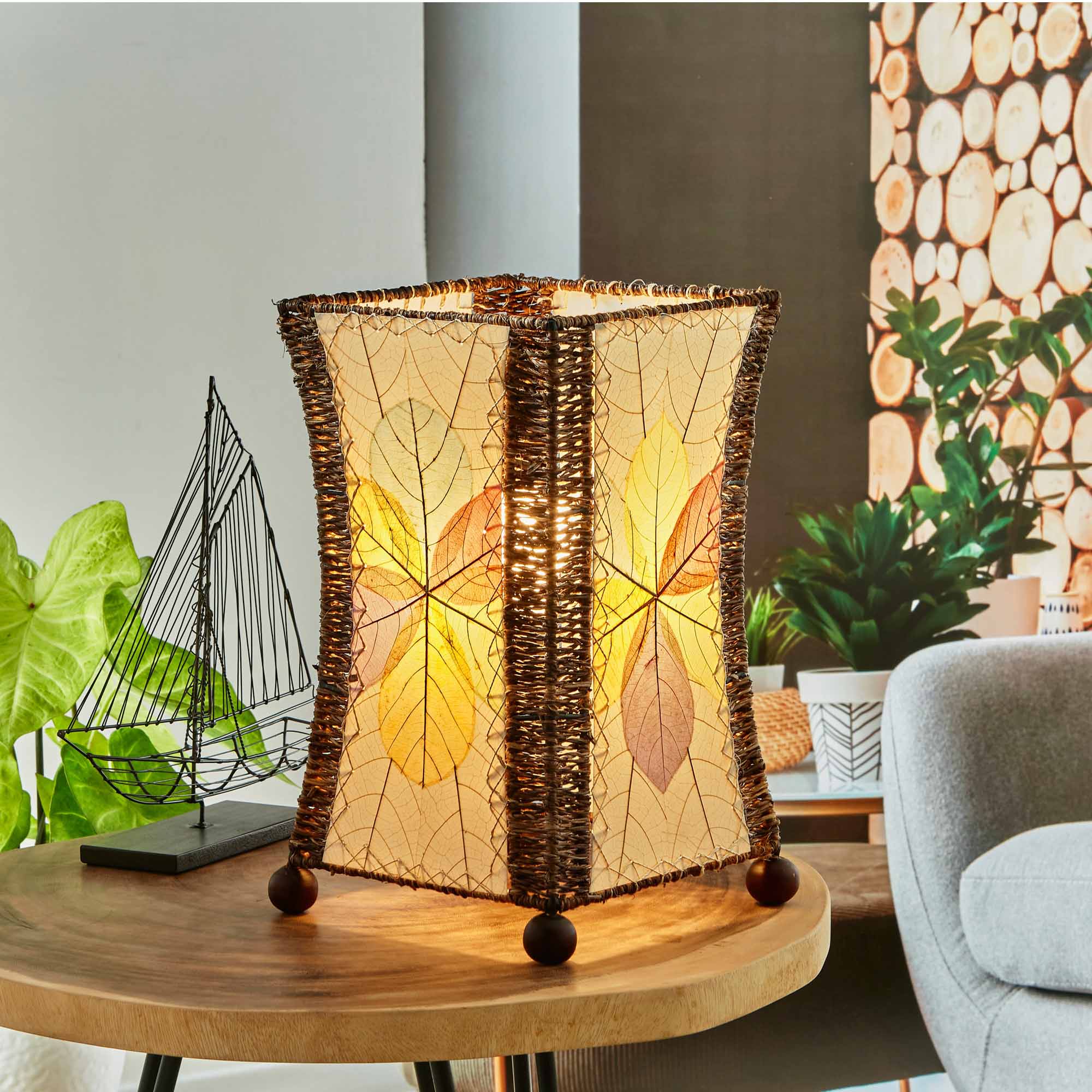 In a minimalist loft with natural textures, crafted by the artisans of Eangee Home Design, the Hourglass Table Lamp in multi color stands gracefully, featuring jackfruit leaf panels, abaca rope accents, wrought iron frame, eco friendly, adding warmth and character to the space.