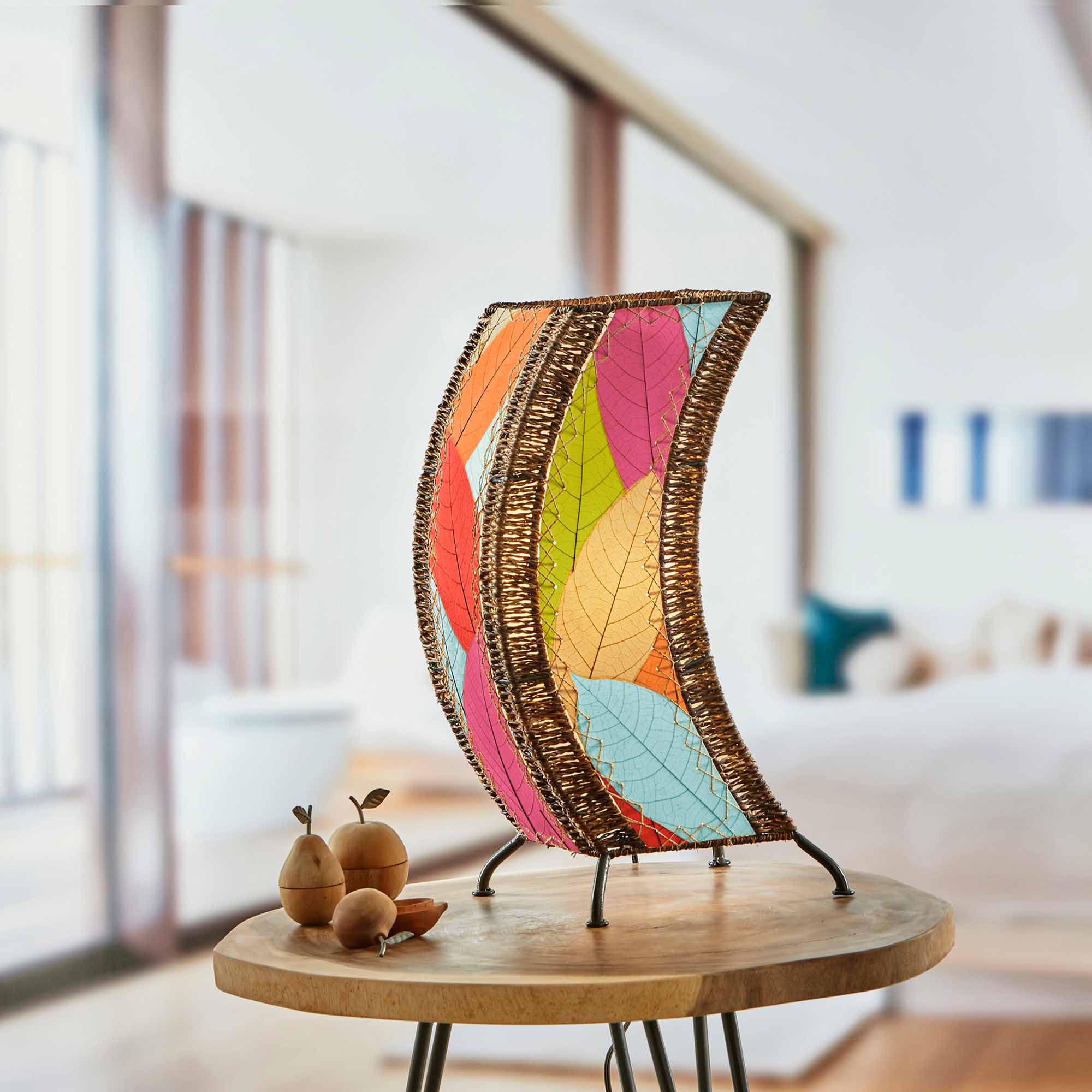 In a modern interior with earth tones, crafted by the artisans of Eangee Home Design, the C Shape Table Lamp in multi color stands gracefully, featuring fossilized cocoa leaf shade, abaca rope accents, fair trade, handcrafted, adding warmth and character to the space.