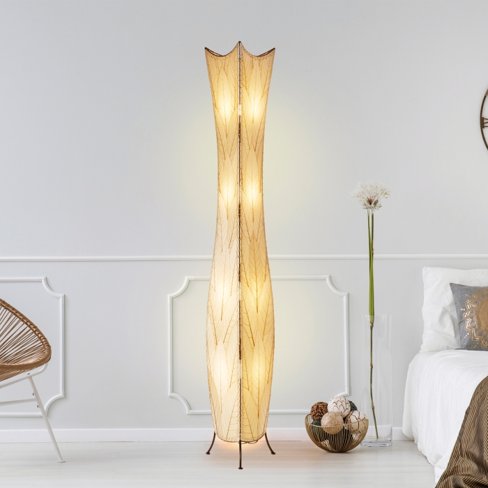 In a modern interior with earth tones, crafted by the artisans of Eangee Home Design, the Flowerbud Giant Floor Lamp in natural stands gracefully, featuring fossilized cocoa leaf shade, adding warmth and character to the space.
