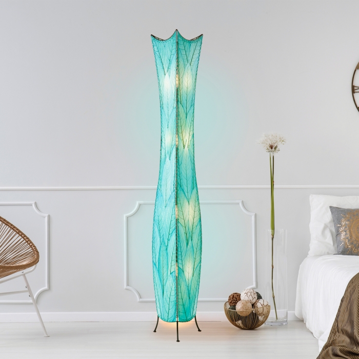 In a softly lit reading nook, crafted by the artisans of Eangee Home Design, the Flowerbud Giant Floor Lamp in sea blue stands gracefully, featuring fossilized cocoa leaf shade, adding warmth and character to the space.