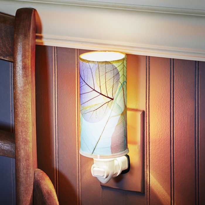 In a coastal inspired living room, crafted by the artisans of Eangee Home Design, the Cylinder Nightlight in multi color stands gracefully, featuring handcrafted detailing, fair trade, eco friendly, adding warmth and character to the space.