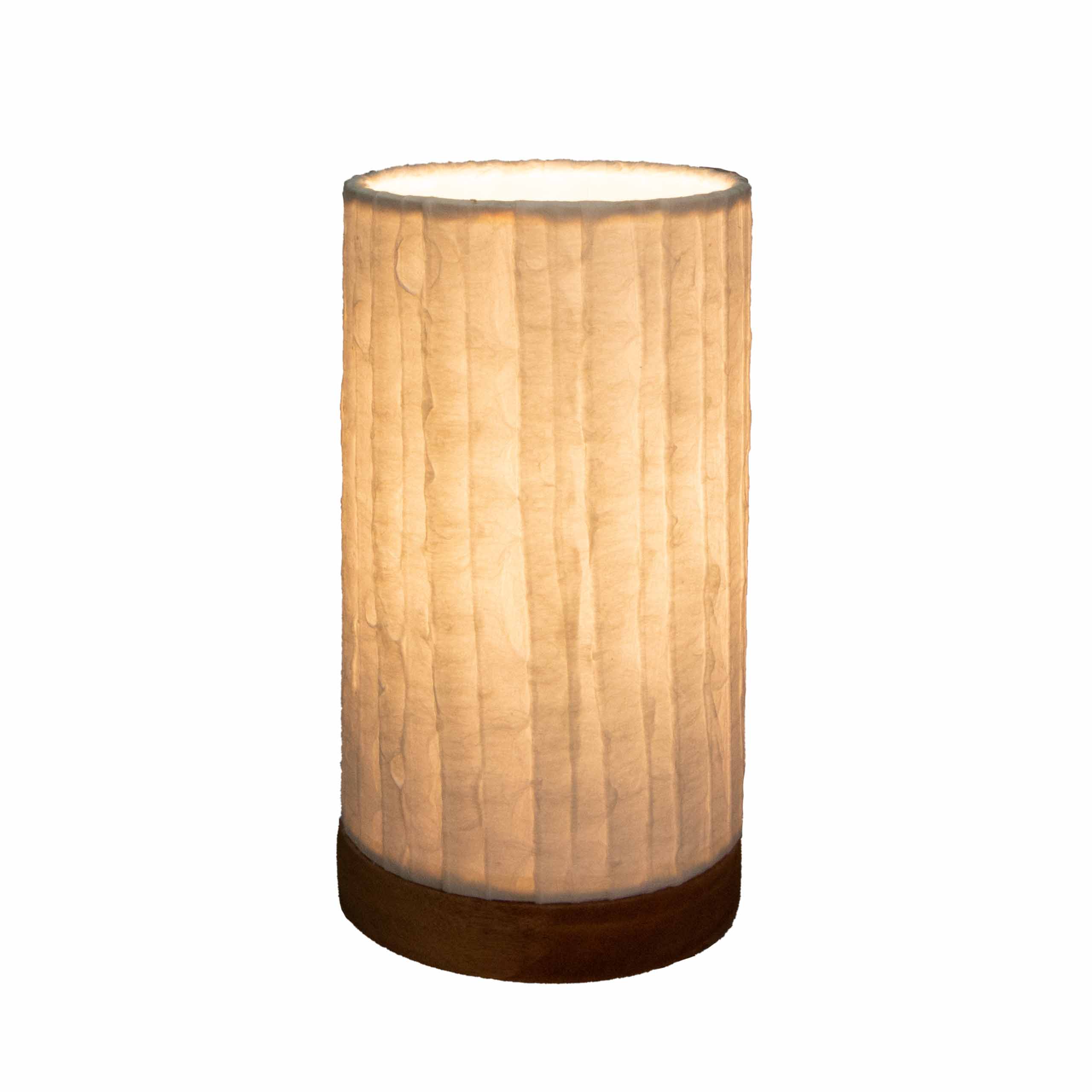 Crafted by the artisans of Eangee Home Design, the Mini Paper Cylinder Table Lamp Lines in natural against a clean backdrop, featuring reclaimed mango wood base, recycled paper shade, sustainably sourced, recycled materials.