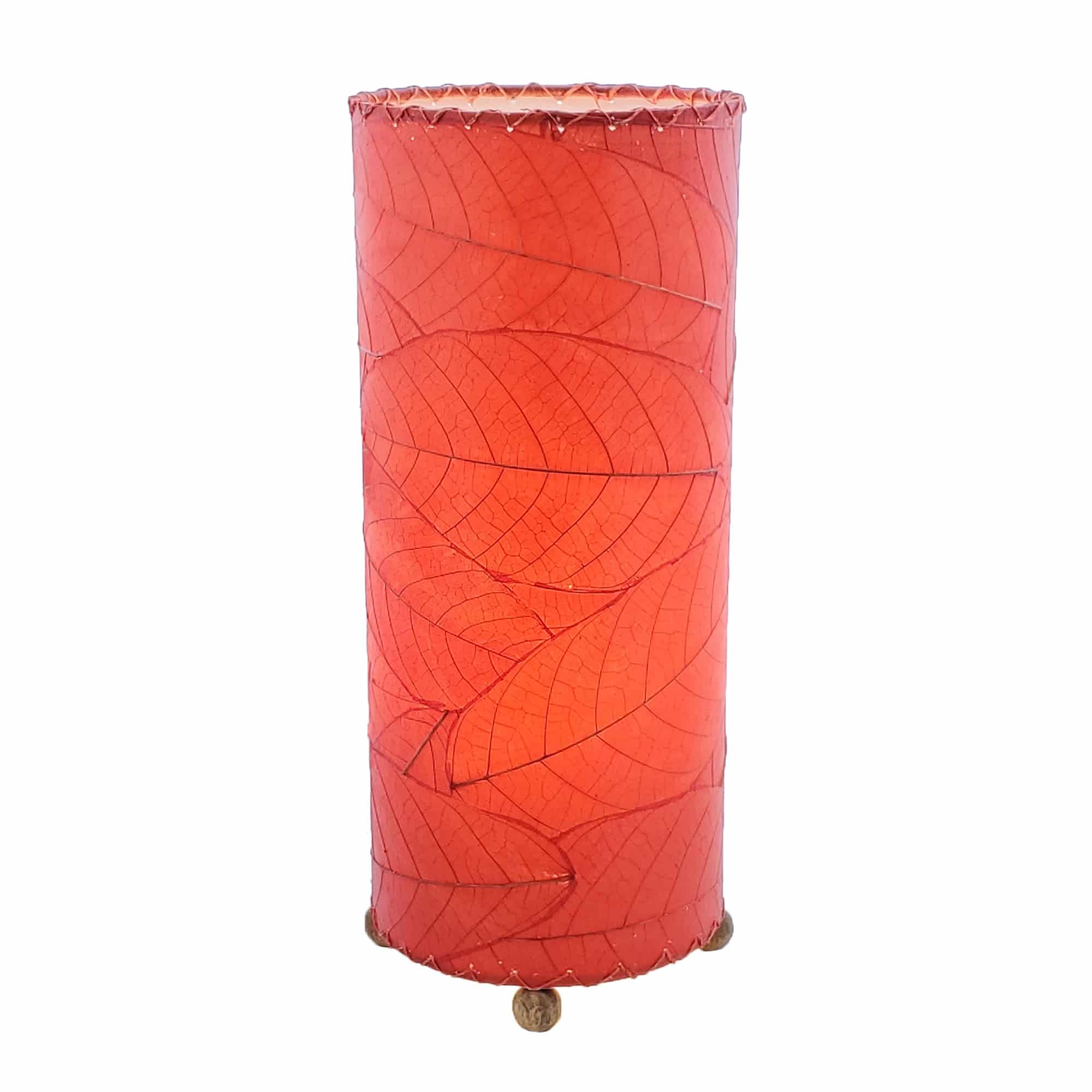 Crafted by the artisans of Eangee Home Design, the Cocoa Leaf Cylinder Table Lamp in red against a clean backdrop, featuring fossilized cocoa leaf shade, wrought iron frame, handcrafted.