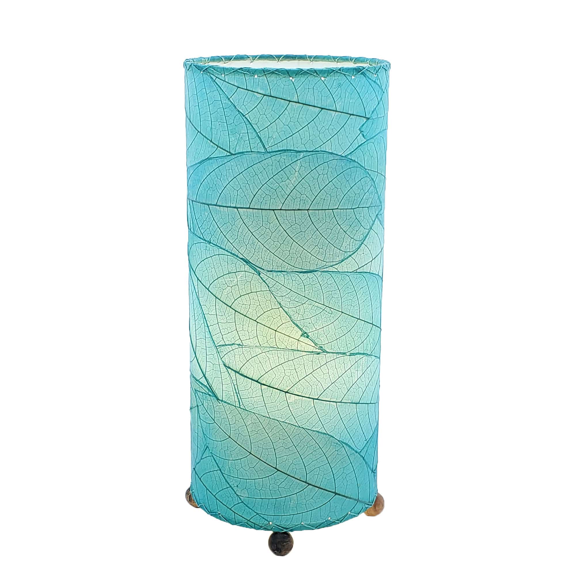 Crafted by the artisans of Eangee Home Design, the Cocoa Leaf Cylinder Table Lamp in sea blue against a clean backdrop, featuring fossilized cocoa leaf shade, wrought iron frame, handcrafted.