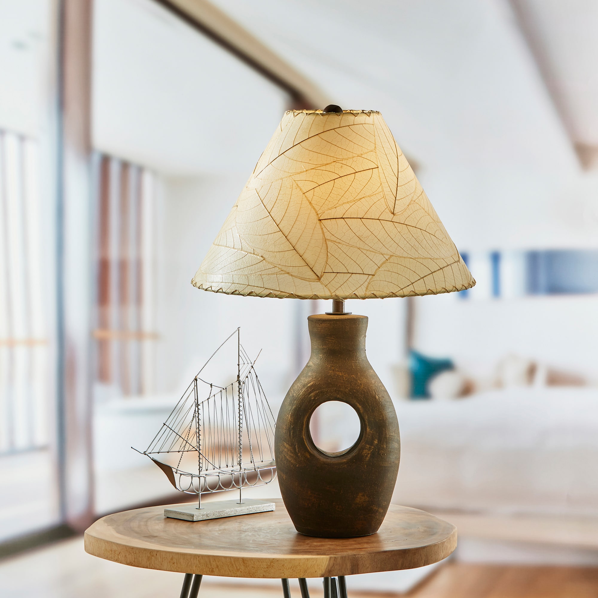 In a minimalist loft with natural textures, crafted by the artisans of Eangee Home Design, the Bell Shade Cocoa in natural stands gracefully, featuring fossilized cocoa leaf shade, wrought iron frame, handcrafted, adding warmth and character to the space.
