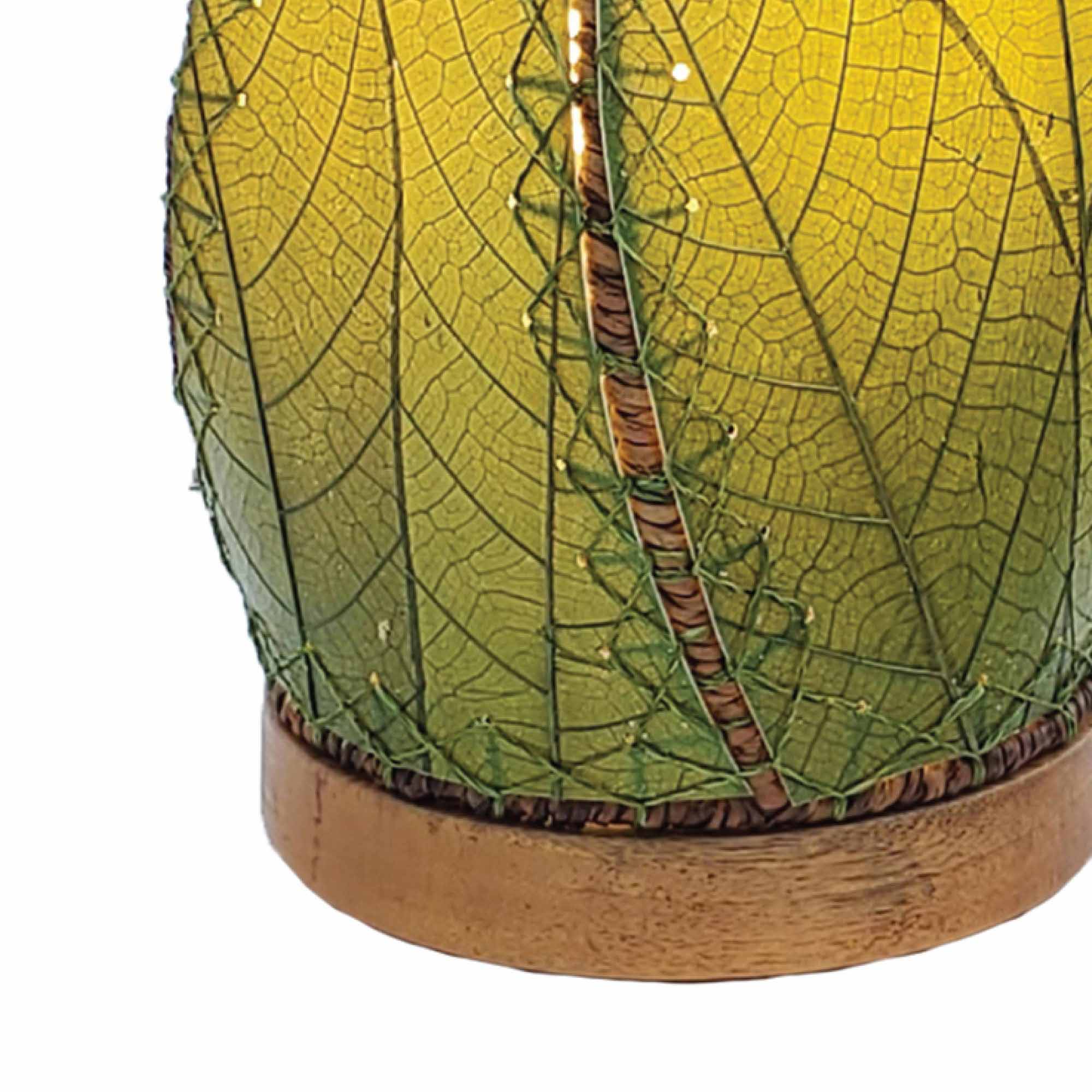 Crafted by the artisans of Eangee Home Design, the Leaflet Table Lamp in green against a clean backdrop, featuring fossilized cocoa leaf shade, abaca rope accents, reclaimed mango wood base, wrought iron frame, sustainably sourced.
