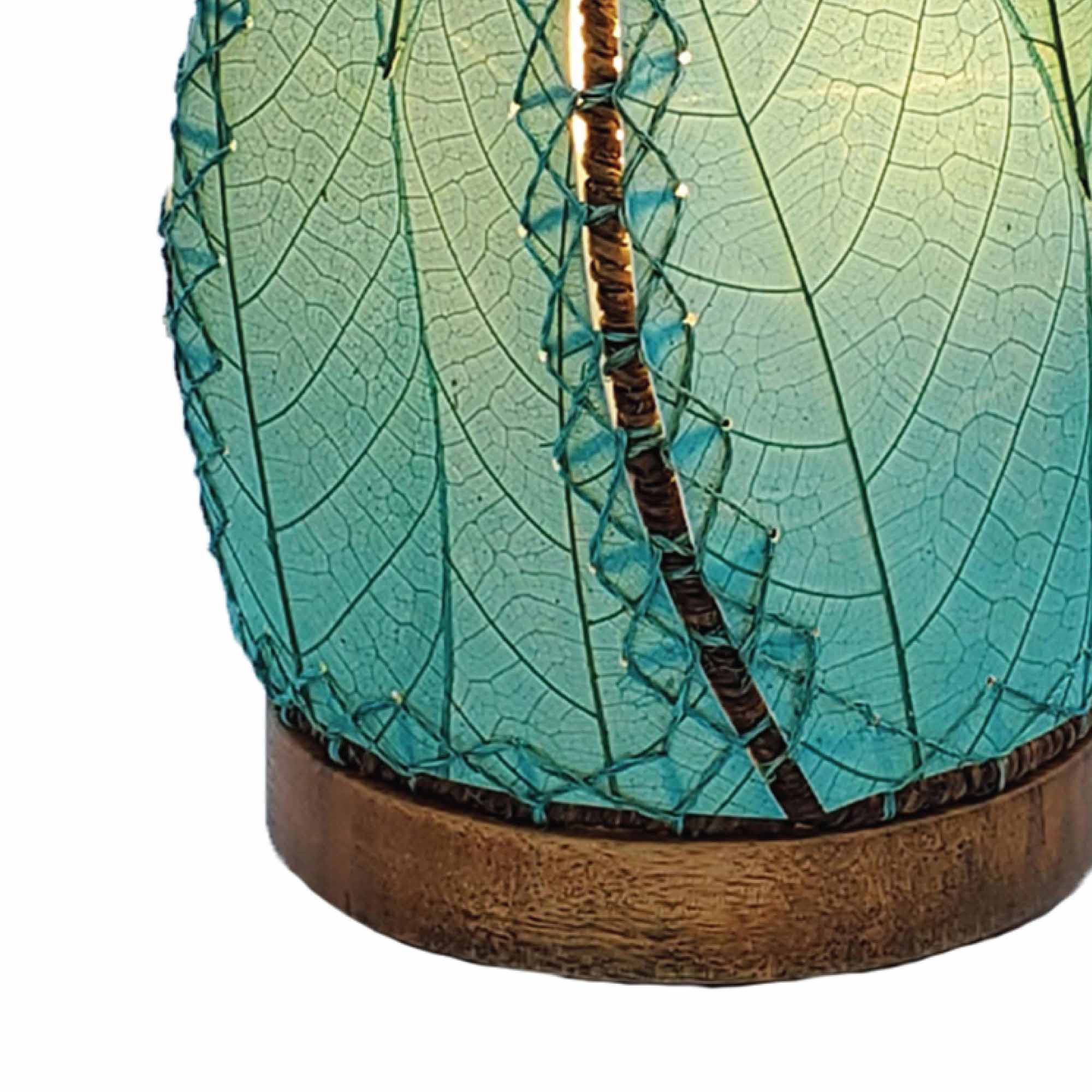 Crafted by the artisans of Eangee Home Design, the Leaflet Table Lamp in sea blue against a clean backdrop, featuring fossilized cocoa leaf shade, abaca rope accents, reclaimed mango wood base, wrought iron frame, sustainably sourced.
