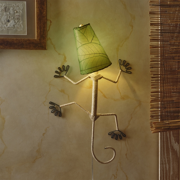 In a modern interior with earth tones, crafted by the artisans of Eangee Home Design, the Gecko Wall Lamp Shade in green hangs, featuring fossilized cocoa leaf shade, abaca rope accents, wrought iron frame, handcrafted, adding warmth and character to the space.