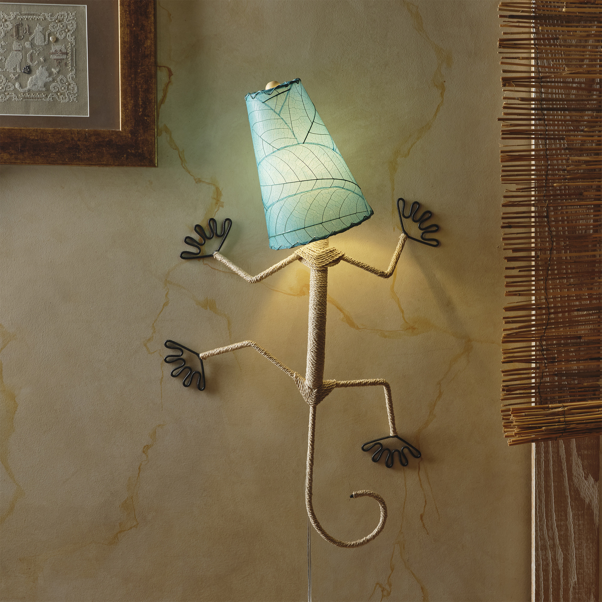 In a quiet bedside corner, crafted by the artisans of Eangee Home Design, the Gecko Wall Lamp Shade in sea blue hangs, featuring fossilized cocoa leaf shade, abaca rope accents, wrought iron frame, handcrafted, adding warmth and character to the space.