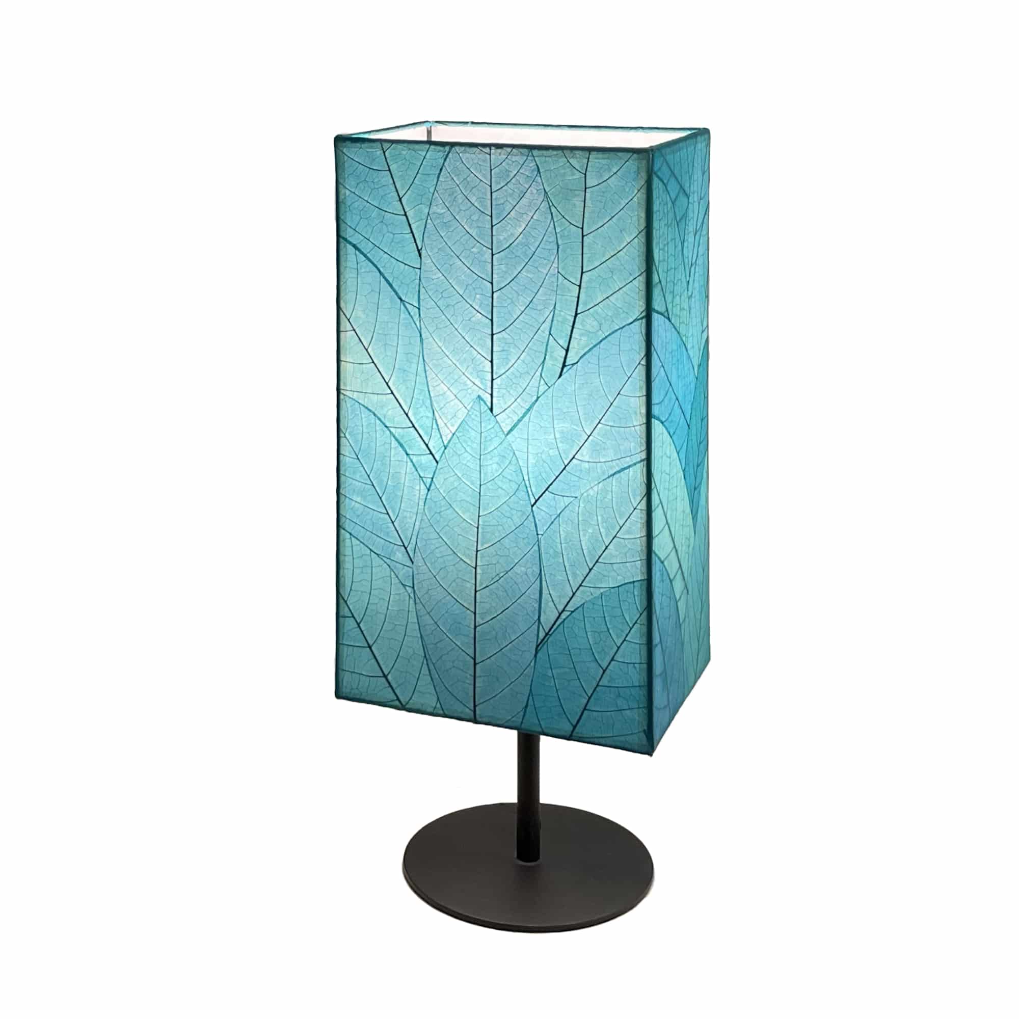 Crafted by the artisans of Eangee Home Design, the Sequoia Table Lamp in sea blue against a clean backdrop, featuring fossilized cocoa leaf shade, fair trade, sustainably sourced.