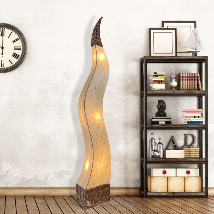 In a coastal inspired living room, crafted by the artisans of Eangee Home Design, the Flame Giant Lamp in natural stands gracefully, featuring fossilized cocoa leaf shade, abaca rope accents, fair trade, adding warmth and character to the space.