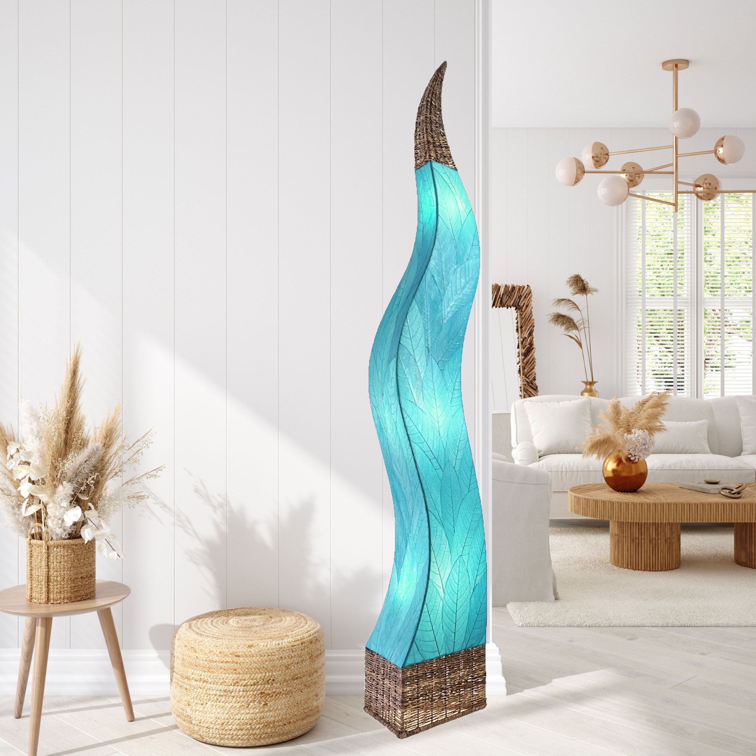 In a coastal inspired living room, crafted by the artisans of Eangee Home Design, the Flame Giant Lamp in sea blue stands gracefully, featuring fossilized cocoa leaf shade, abaca rope accents, fair trade, adding warmth and character to the space.