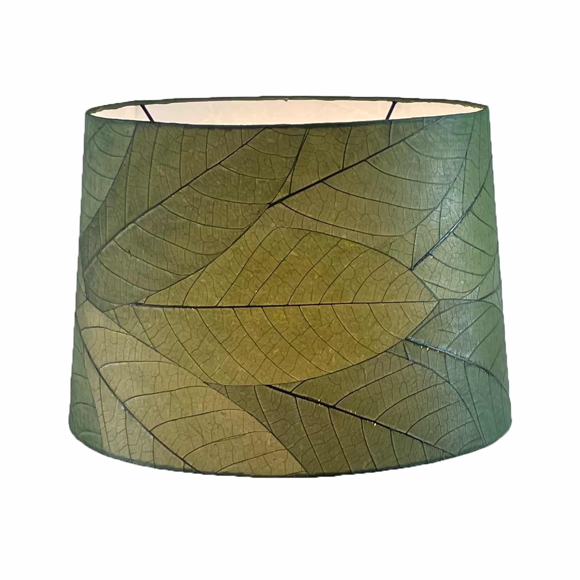 Crafted by the artisans of Eangee Home Design, the 16 Inch Tapered Drum Shade in green against a clean backdrop, featuring fossilized cocoa leaf shade, wrought iron frame, fair trade, sustainably sourced, handcrafted.