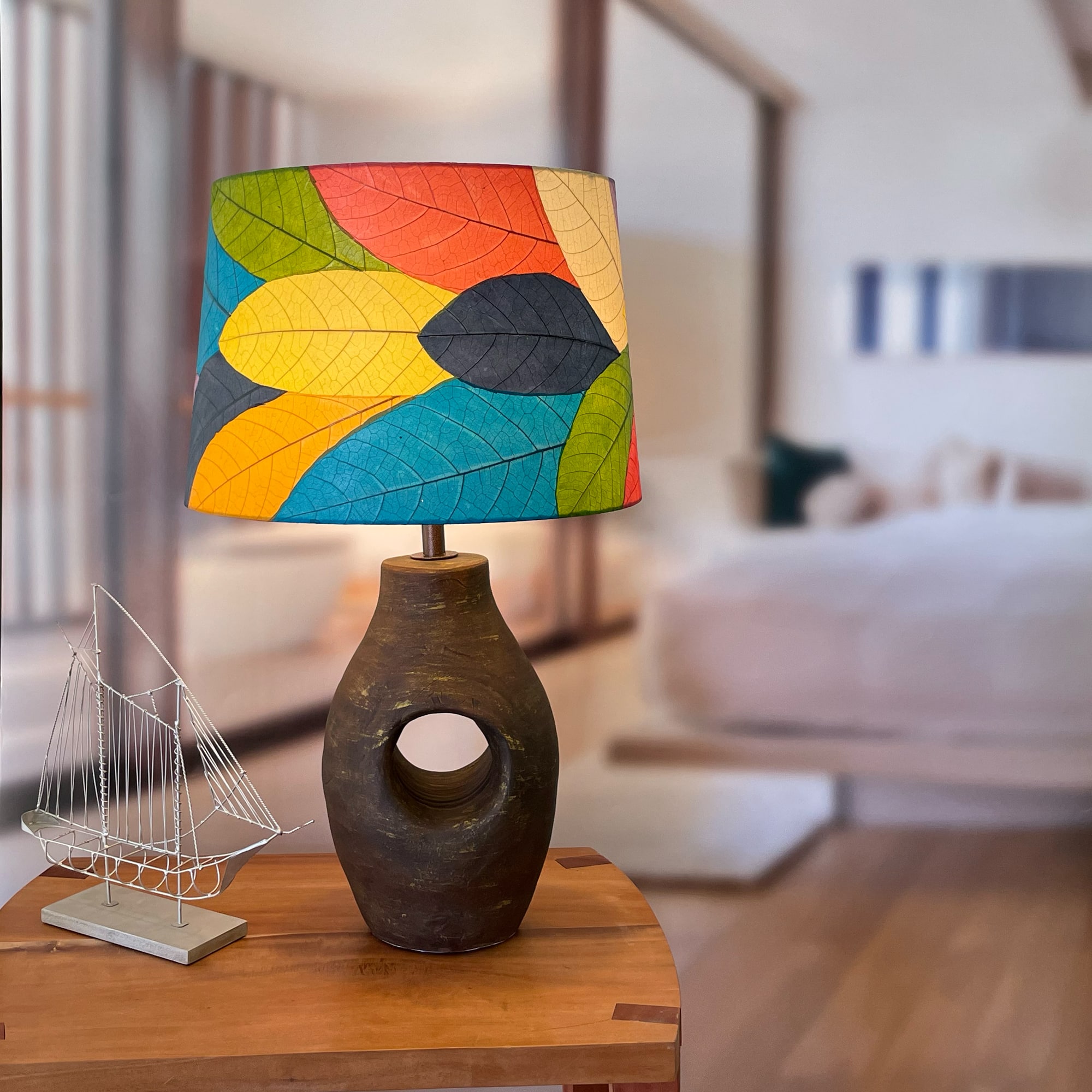 Crafted by the artisans of Eangee Home Design, the 16 Inch Tapered Drum Shade in multi color against a clean backdrop, featuring fossilized cocoa leaf shade, wrought iron frame, fair trade, sustainably sourced, handcrafted.