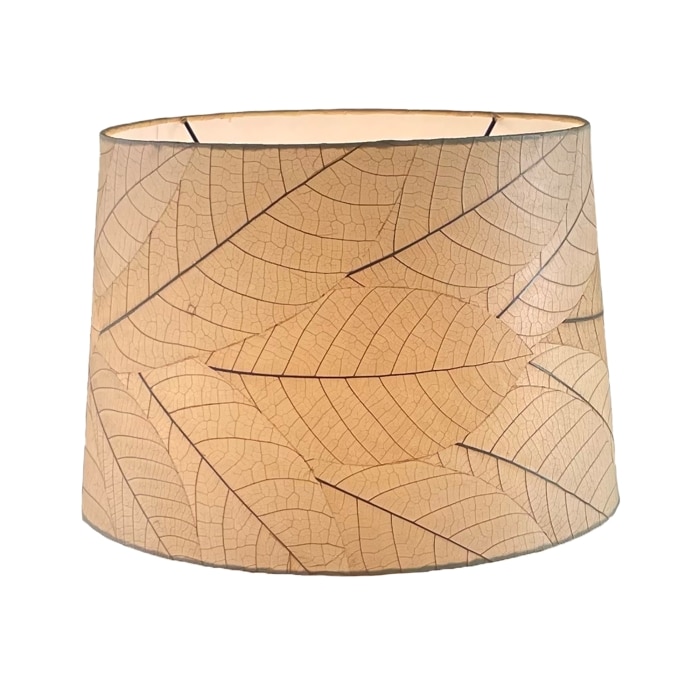 Crafted by the artisans of Eangee Home Design, the 16 Inch Tapered Drum Shade in natural against a clean backdrop, featuring fossilized cocoa leaf shade, wrought iron frame, fair trade, sustainably sourced, handcrafted.