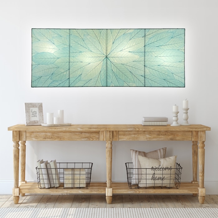 Crafted by the artisans of Eangee Home Design, the Sunburst Panel Wall Lamp in sea blue against a clean backdrop, featuring fossilized cocoa leaf shade, fair trade.