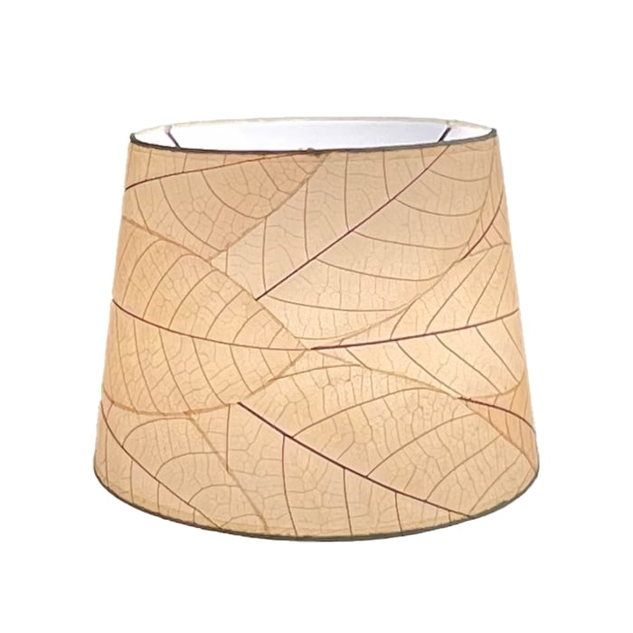 Crafted by the artisans of Eangee Home Design, the 12 Inch Tapered Drum Shade in natural against a clean backdrop, featuring fossilized cocoa leaf shade, fair trade.