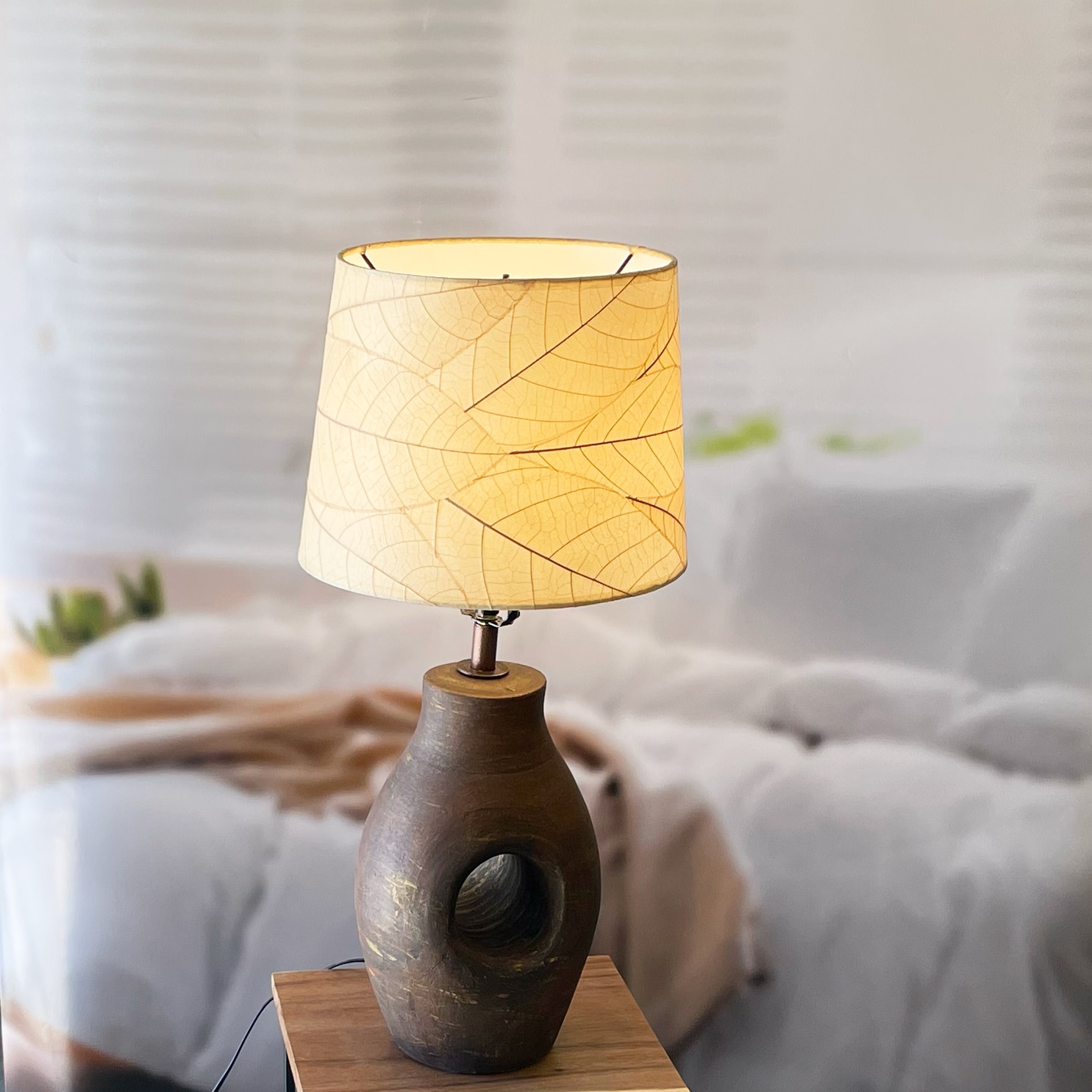 In a coastal inspired living room, crafted by the artisans of Eangee Home Design, the 12 Inch Tapered Drum Shade in natural stands gracefully, featuring fossilized cocoa leaf shade, fair trade, adding warmth and character to the space.