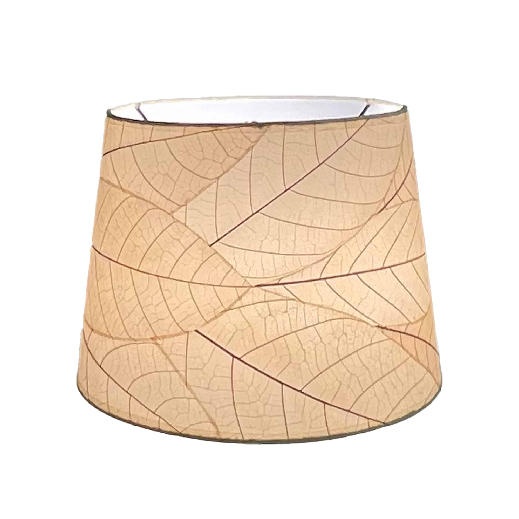 Crafted by the artisans of Eangee Home Design, the 12 Inch Tapered Drum Shade in natural against a clean backdrop, featuring fossilized cocoa leaf shade, fair trade.