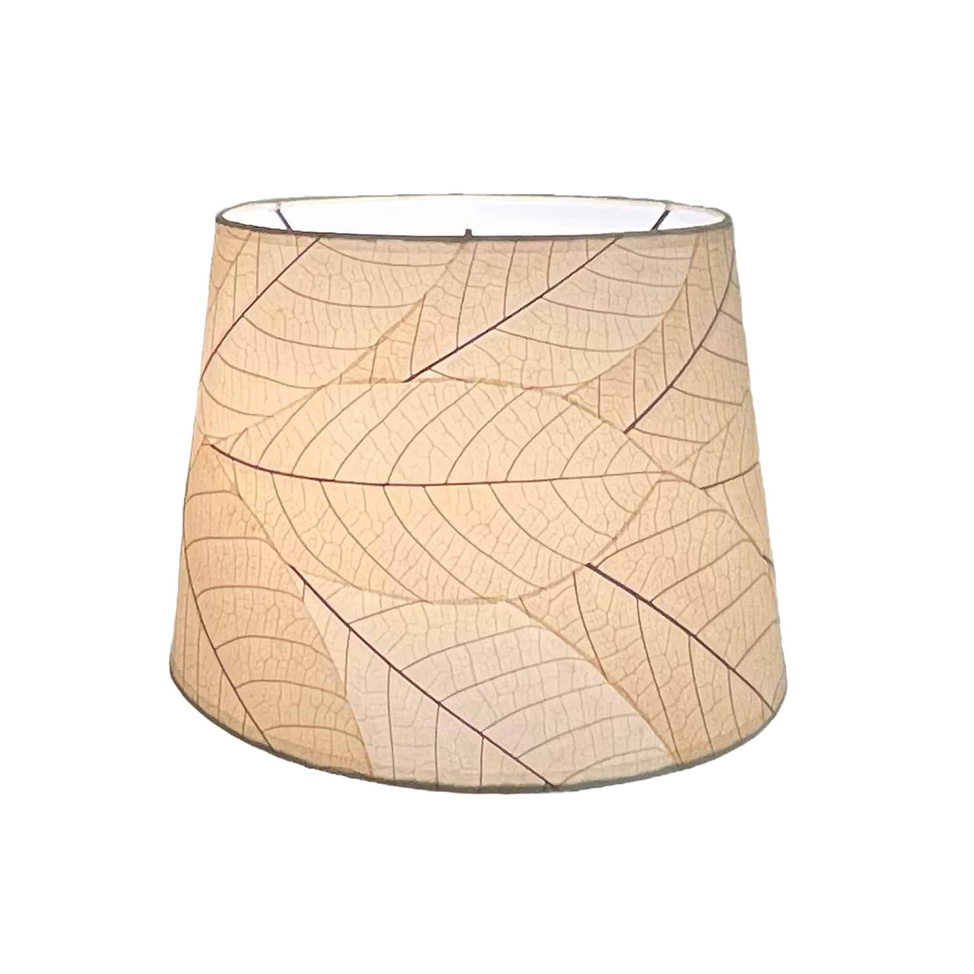 Crafted by the artisans of Eangee Home Design, the 14 Inch Tapered Drum Shade in natural against a clean backdrop, featuring fossilized cocoa leaf shade, wrought iron frame, fair trade, eco friendly, sustainably sourced, handcrafted.