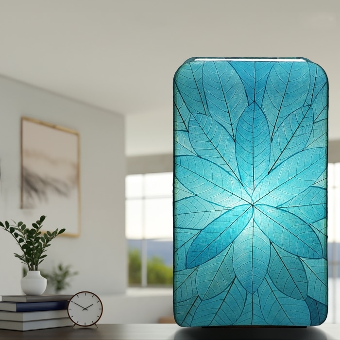 In a coastal inspired living room, crafted by the artisans of Eangee Home Design, the Sunburst Giant Floor Lamp in sea blue stands gracefully, featuring fossilized cocoa leaf shade, fair trade, handcrafted, adding warmth and character to the space.