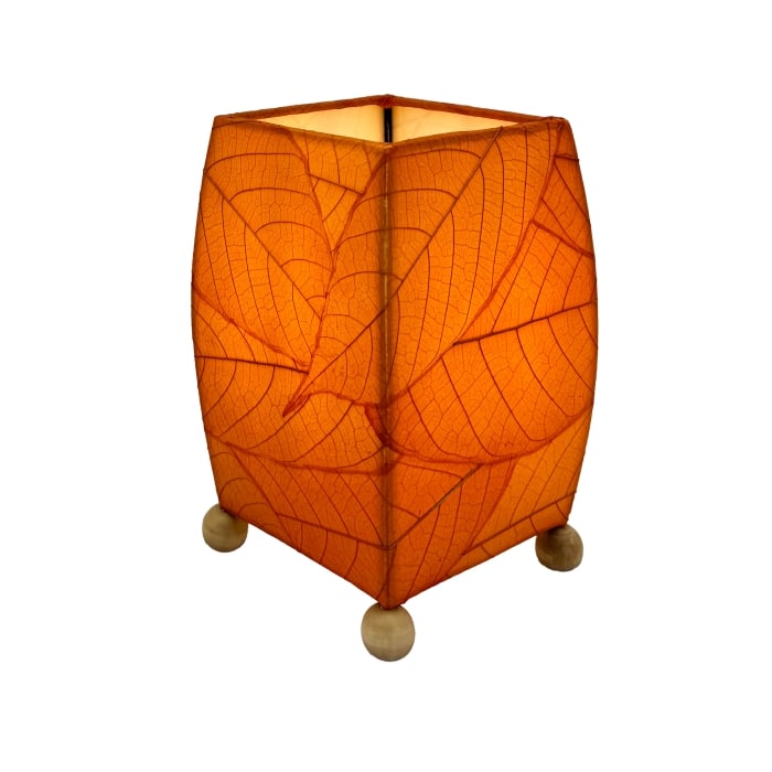 Crafted by the artisans of Eangee Home Design, the Mini Square Cocoa Leaf Table Lamp in orange against a clean backdrop, featuring fossilized cocoa leaf shade, wrought iron frame, fair trade, eco friendly, sustainably sourced, handcrafted.
