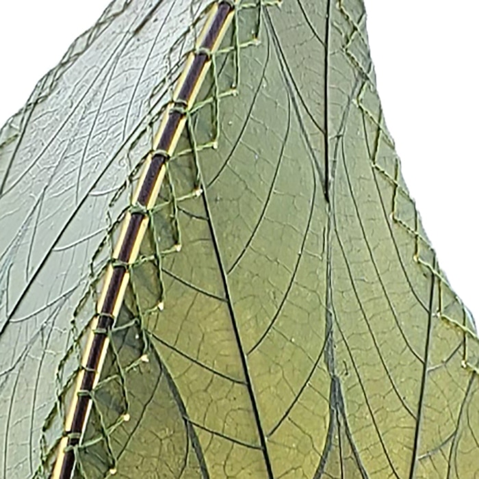 In a minimalist loft with natural textures, crafted by the artisans of Eangee Home Design, the 24 Inch Leaflet Lamp in green stands gracefully, featuring fossilized cocoa leaf shade, abaca rope accents, wrought iron frame, handcrafted, adding warmth and character to the space.