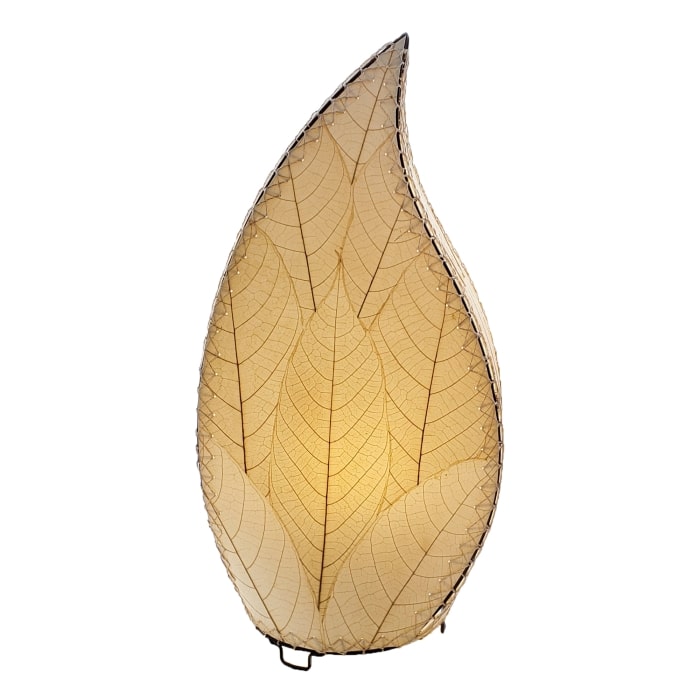 In a softly lit reading nook, crafted by the artisans of Eangee Home Design, the 24 Inch Leaflet Lamp in natural stands gracefully, featuring fossilized cocoa leaf shade, abaca rope accents, wrought iron frame, handcrafted, adding warmth and character to the space.