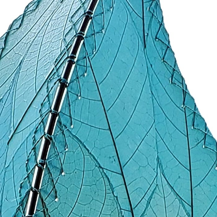 In a quiet bedside corner, crafted by the artisans of Eangee Home Design, the 24 Inch Leaflet Lamp in sea blue stands gracefully, featuring fossilized cocoa leaf shade, abaca rope accents, wrought iron frame, handcrafted, adding warmth and character to the space.