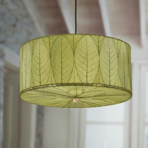 In a coastal inspired living room, a green lamp crafted by the artisans of Eangee Home Design called the Drum Pendant 24 Inch stands gracefully, featuring handcrafted detailing, sustainably sourced, handcrafted, adding warmth and character to the scene.
