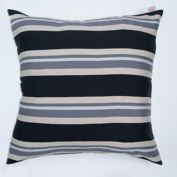 Black outdoor pillow crafted by the artisans of Magnolia Casual called the Rayas Pillow Gray Black featuring traditional backstrap loom weave, handwoven textile, handcrafted shown against a clean backdrop featuring shades of gray and black.