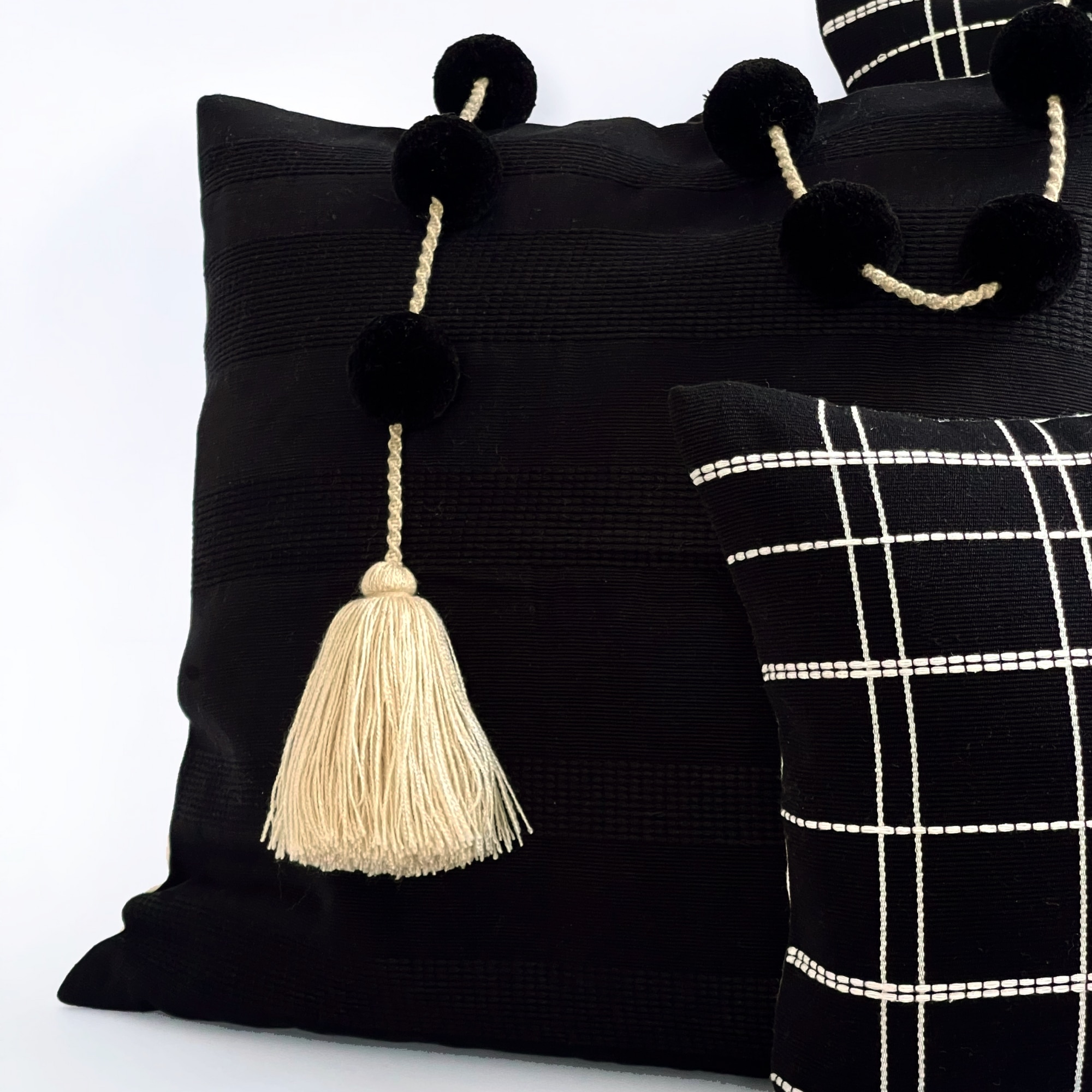 Black pillow cover crafted by the artisans of Magnolia Casual called the Lines Pillow Cover Black featuring handwoven textile, handcrafted shown against a clean backdrop featuring shades of black.