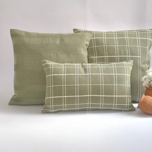 Green pillow cover crafted by the artisans of Dos Tierras called the Broken Grid Pillow Cover Green featuring handwoven textile, handcrafted shown against a clean backdrop featuring with a grid motif and shades of green.