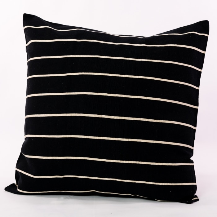 Black pillow cover crafted by the artisans of Magnolia Casual called the Rayas 2 Pillow Cover Black featuring handwoven textile, handcrafted shown against a clean backdrop featuring shades of black.